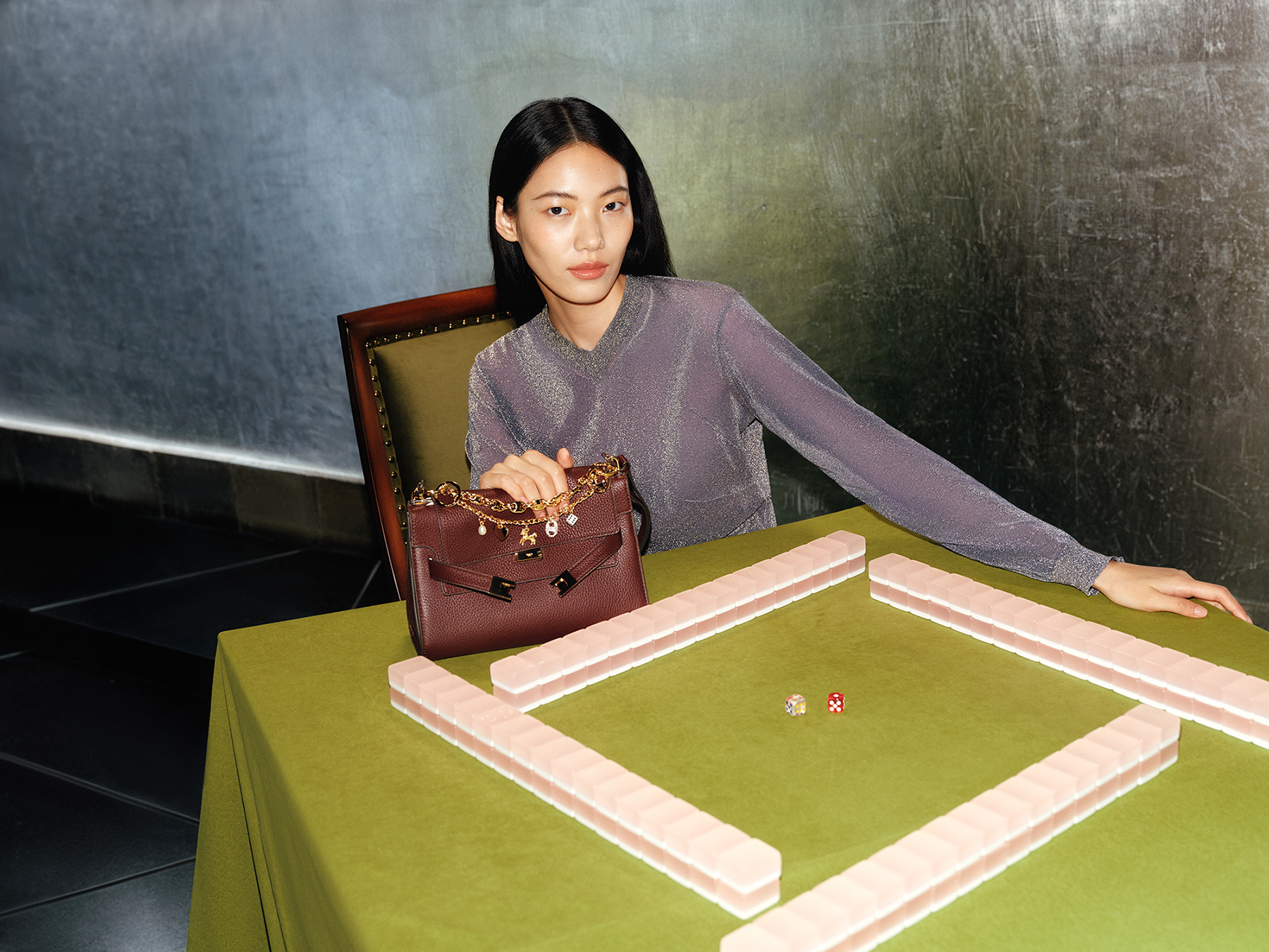 Người mẫu trình diễn túi xách Tory Burch trên bàn cờ ngựa với xúc xắc